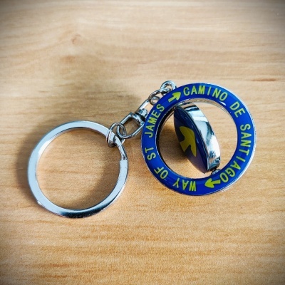 Porta-chaves metálico com anel e círculo azul com texto amarelo