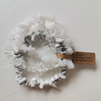 Pulseiras elásticas brancas e cinzentas de pedras naturais com etiqueta de cartão castanho