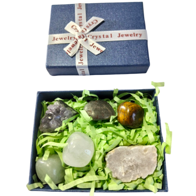 Caixa de joias azul escura com pedras polidas coloridas e enchimento verde