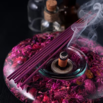 Incensário em vidro com flores secas e incenso a arder