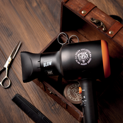 Secador preto com texto em caixa de madeira com tesouras e pente.