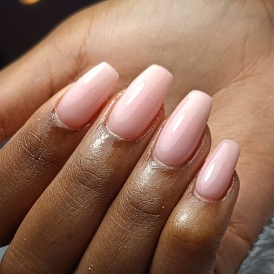 Mãos com unhas postiças cor rosa claro brilhante