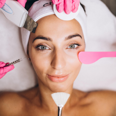 Mulher a receber tratamentos faciais com diversos instrumentos enquanto está deitada