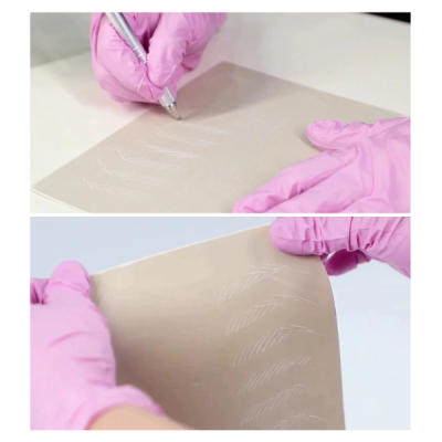Mãos com luvas rosas a riscar linhas brancas numa folha castanha clara flexível
