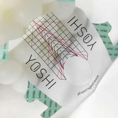 Embalagem branca com design gráfico e etiquetas verdes da marca YOSHI