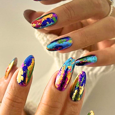 Unhas artificiais coloridas com acabamento brilhante e padrão abstrato.