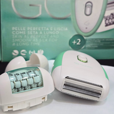 Depiladora elétrica branca e verde com cabeçalhos, embalagem verde ao fundo com texto e símbolos.