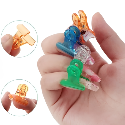 Mãos segurando molas coloridas de plástico com padrões florais em fundo branco