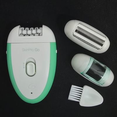 Aparelho de depilação SkinPro Go com acessórios e pincel de limpeza sobre fundo preto