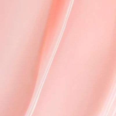 Superfície creme rosada com textura suave e linhas onduladas brilhantes.