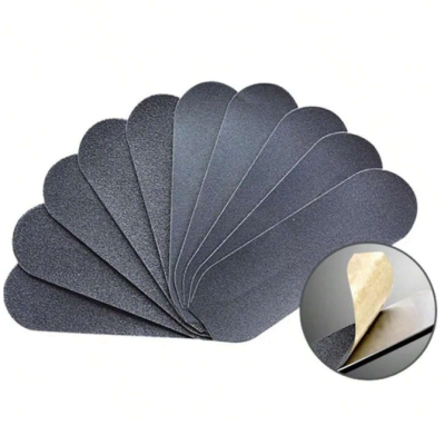 Autocolantes antiderrapantes pretos em formato oval com película removível sobre fundo branco