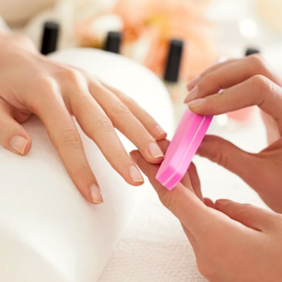 Mãos com unhas naturais e uma lixa rosa de unhas