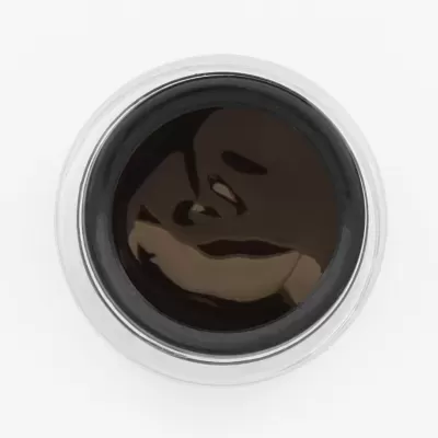 Jarra de vidro com líquido negro e tampa metálica vista de cima