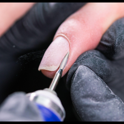 Manicure a lixar unha natural com máquina, luvas pretas.