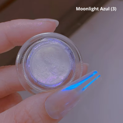 Frasco com pó cintilante branco e unhas com verniz transparente e detalhes azuis