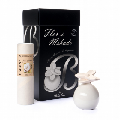 Conjunto difusor Mikado com embalagem preta e difusor cerâmico branco com flor.