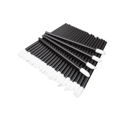 Aplicadores pretos com pontas de algodão branca dispostos em fileira sobre fundo branco