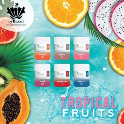Frascos coloridos de produtos cosméticos com nomes de frutas tropicais sobre fundo azul com frutas fatiadas