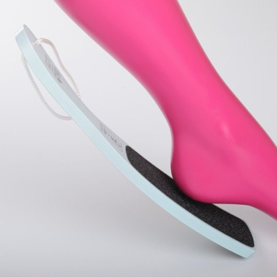 Lixa de pé azul clara com superfície preta e corda branca junto a perna rosa artificial.