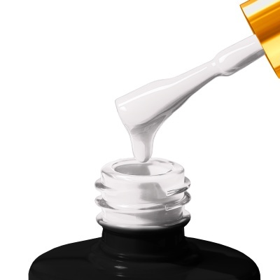 Frasco de verniz preto aberto com pincel a aplicar verniz branco