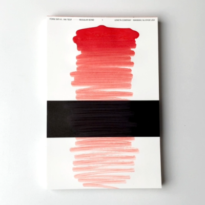 Bloco de papel branco com manchas vermelhas, pretas, faixa preta e texto no topo