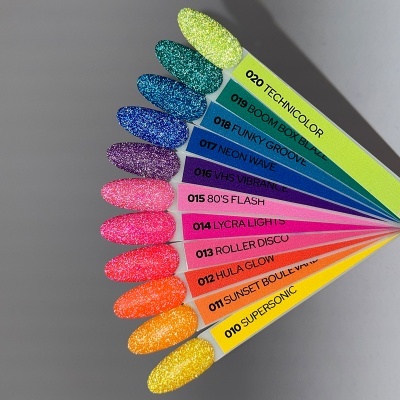 Amostras de unhas postizas coloridas com brilho e etiquetas com nomes e números.