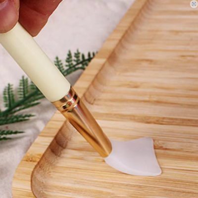 Pincel de maquilhagem a aplicar creme numa base de madeira