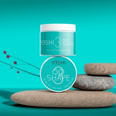 Frascos redondos turquesa de gel construtor YOSHI 3 GO SHAPE sobre pedras cinzentas.