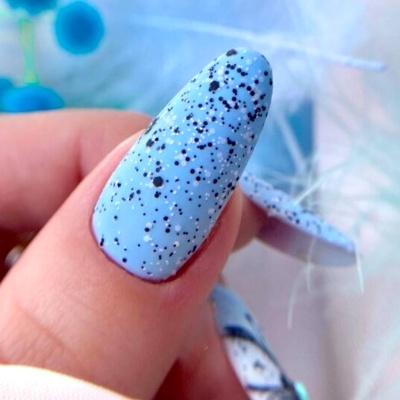Unha com verniz azul claro com pontos pretos e brancos