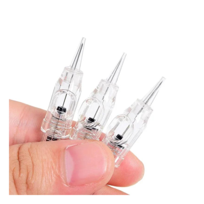 Três agulhas transparentes para tatuagem com ponta fina, seguradas entre os dedos