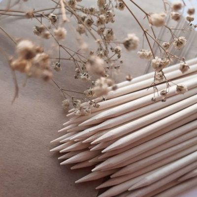 Lápis de madeira naturais com pontas afiadas empilhados junto a flores secas