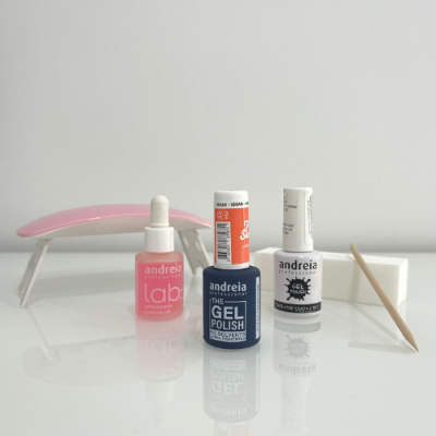 Kit de verniz gel Andreia com três frascos, aplicador de madeira e ferramenta rosa sobre fundo branco