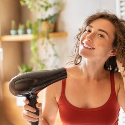 Pessoa a usar um secador de cabelo preto