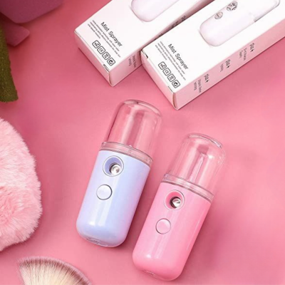 Dois humidificadores Mini Sprayer azul claro e rosa com tampa plástica transparente em fundo rosa