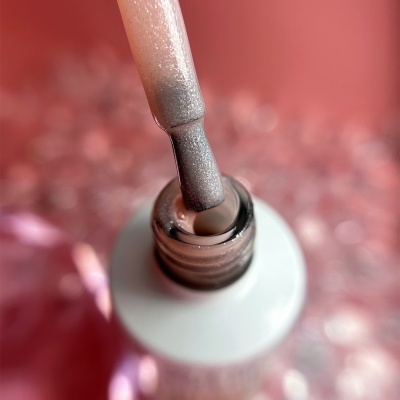 Pincel de verniz dentro de frasco aberto com verniz cor cinza claro brilhante