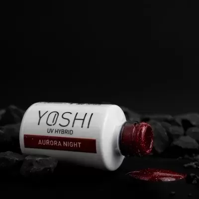 Frasco branco de verniz gel UV Hybrid YOSHI Aurora Night sobre pedras pretas