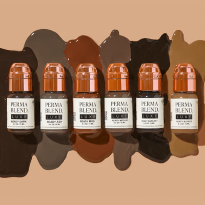 Frascos de tinta para sobrancelhas PERMA BLEND LUXE em várias cores sobre fundo bege