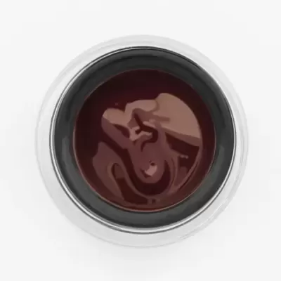 Recipiente metálico com líquido castanho escuro visto de cima.