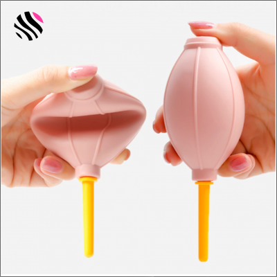 Sopros de ar de borracha rosa com bico amarelo nas mãos