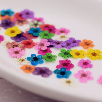 Flores artificiais coloridas sobre recipiente branco