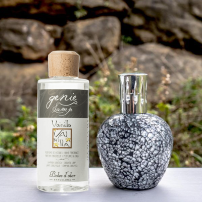 Difusores de aroma em vidro transparente e marmoreado com tampas em madeira e metal sobre superfície branca