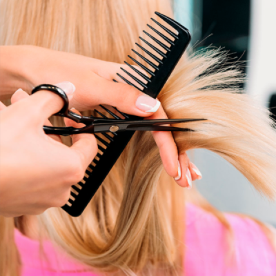 Mãos a cortar cabelo loiro com tesoura e pente pretos
