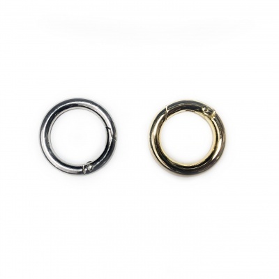 Dois anéis metálicos, um prata e outro dourado, sobre fundo branco