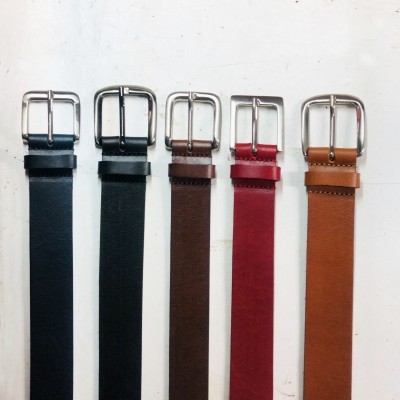 Cinco cintos de couro em diferentes cores com fivelas metálicas sobre fundo branco