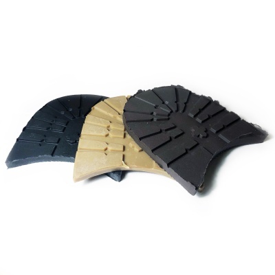 Três solas para sapatos em borracha com texturas antiderrapantes de cores preta, camel e castanha