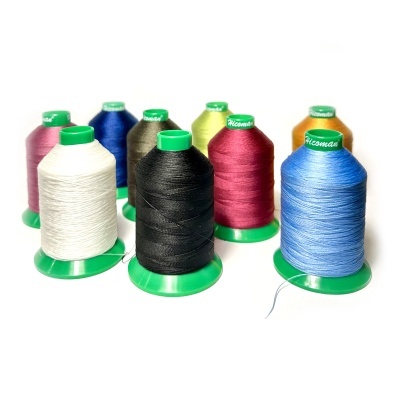 Oito carretéis de linha de costura de várias cores com bases verdes