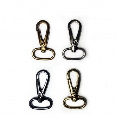 Quatro mosquetões metálicos dourados, prateados e pretos sobre fundo branco