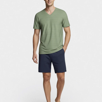 Homem com t-shirt verde e calções azuis escuros em fundo branco
