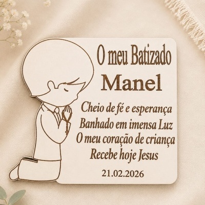 Placa de madeira clara com ilustração de menino a rezar e texto gravado sobre tecido bege.