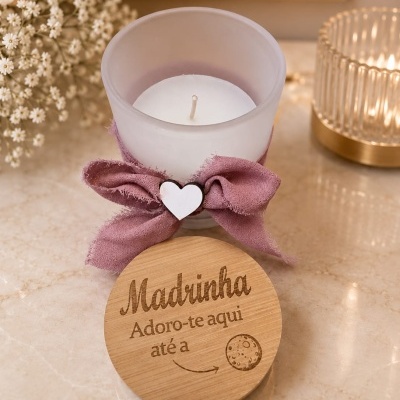 Vela decorativa com tampa de madeira e laço rosa num ambiente elegante
